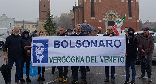 Andrea Zanoni con cartello contro Bolsonaro
