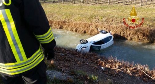 Ragazza esce di strada e finisce nel canale ribaltandosi